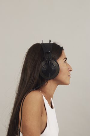 Thoughtful young woman enjoying music in studio