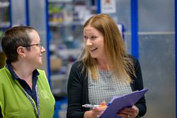 Two coworkers talking about stock in warehouse