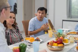 White couple having dinner with Asian friends