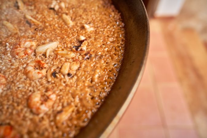 Appetizing paella in pan during process of cooking