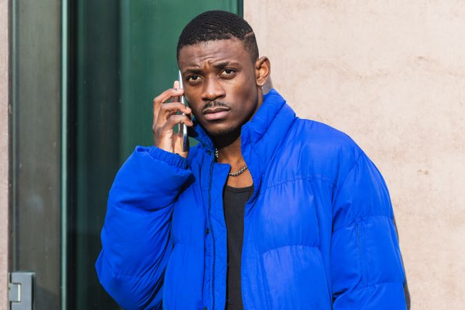 Stylish Black man chatting on social media on cellphone