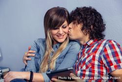 Man kissing woman while holding tablet 5lVmrY