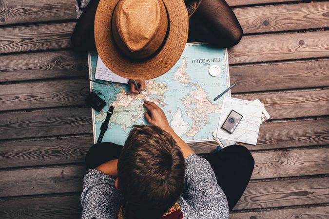 Two people planning trip with world map