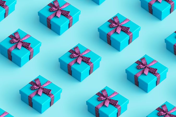 Aqua present boxes with purple ribbon over aqua background