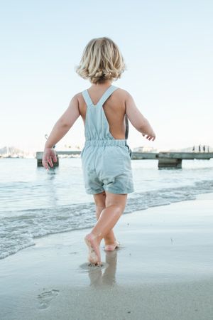 Toddler walking on sandy beach