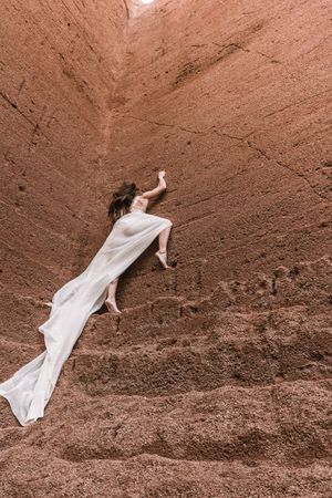 Elegant female posing on rocky cliff
