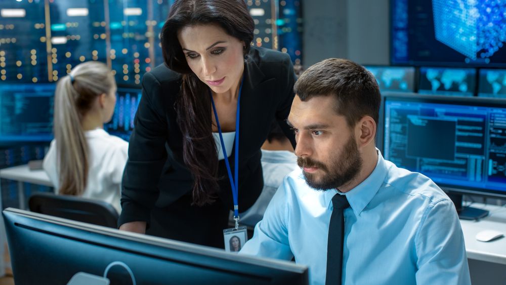 Female Chief Computer Engineer Consults Male Neural Network Architect.