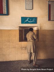 Back view of a man wearing kurta standing at a booth 4jD3x0