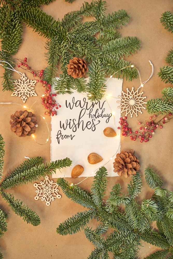 Christmas greeting written with a beautiful handmade letter with Christmas decorations and lights around.