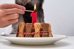 Faceless person with burning candle at table