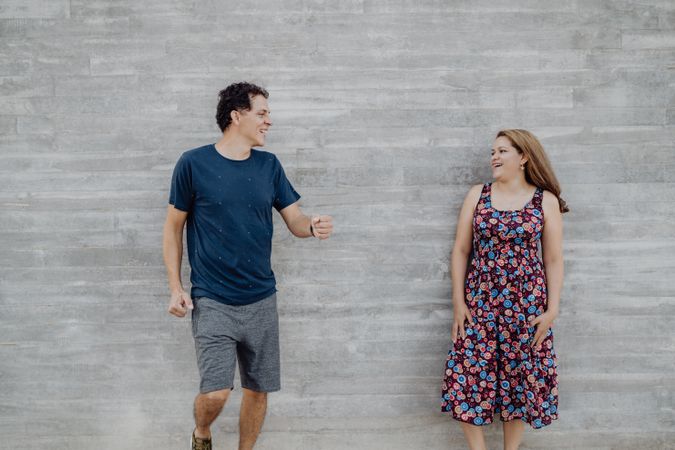 man and woman looking each other at nearby street wall