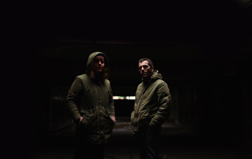 A couple standing together in the darkness.