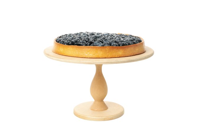 Wooden board with blueberry pie isolated on light background