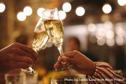 Couple toasting champagne glasses at dinner date 4ZOB1b