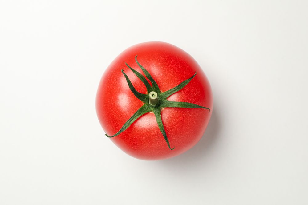 Fresh tomato on neutral background, top view and close up