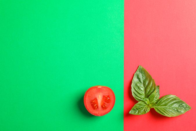 Fresh cherry tomato and basil on two tone background, space for text. Ripe vegetables
