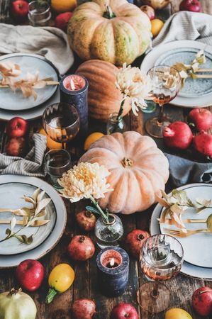 Fall table setting with squash, candles and pomegranates