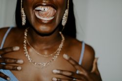 Black woman wearing gold jewelry smiling 0yMXW0