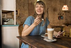 Woman holding spoon with slice of cake