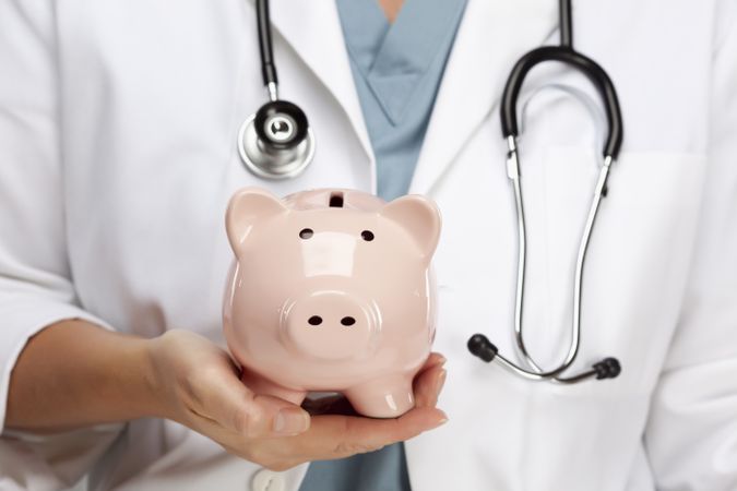 Doctor with Stethoscope Holding Piggy Bank Abstract