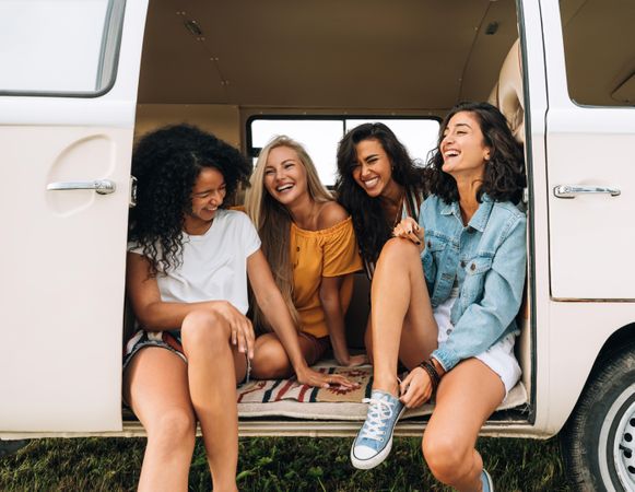 Four friends sitting in the back of a van