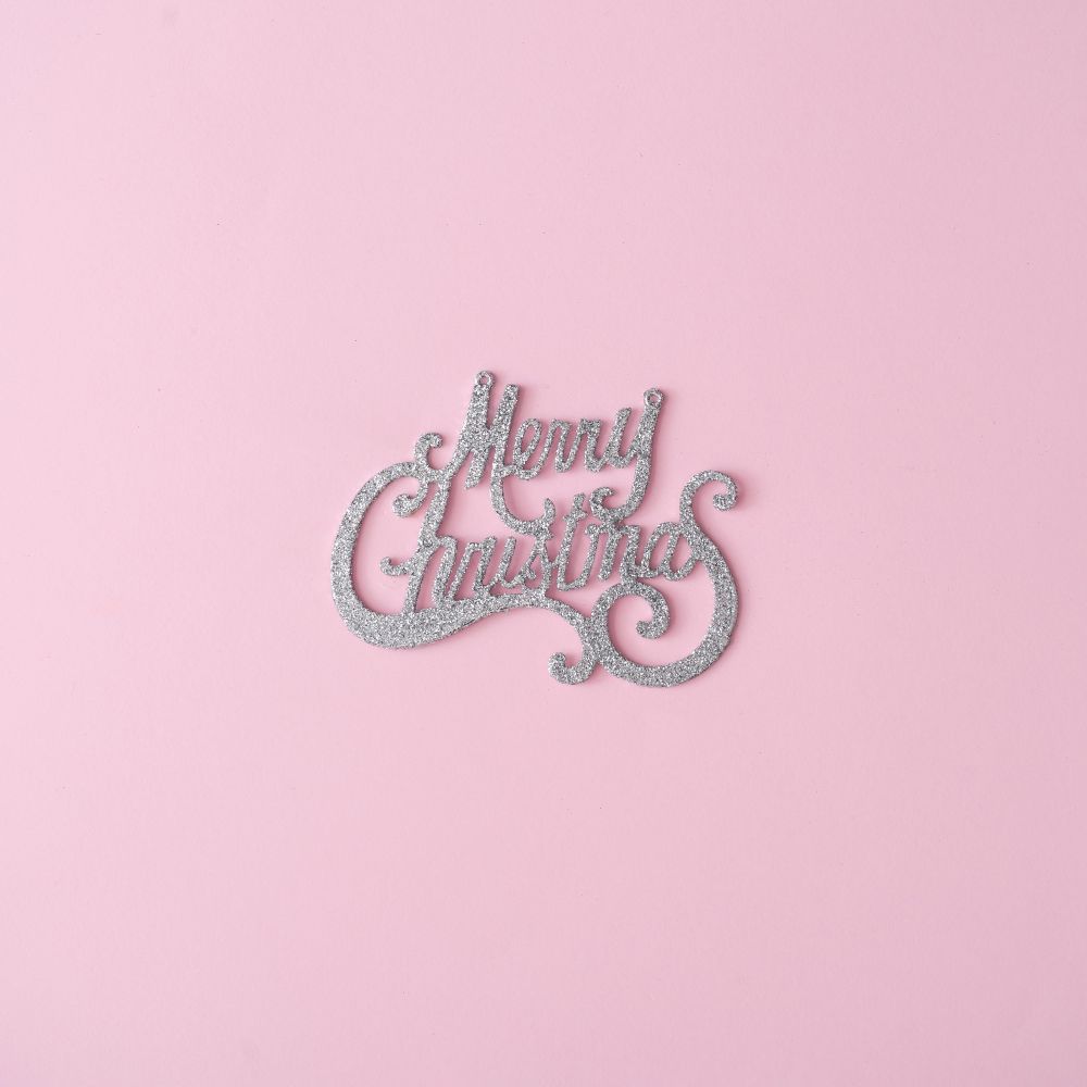 Merry Christmas glitter sign on pastel pink background