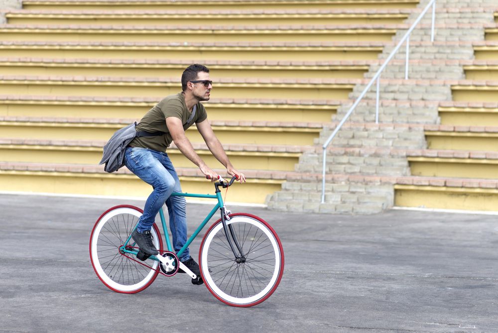 Male on bike with yellow outdoor seats in background