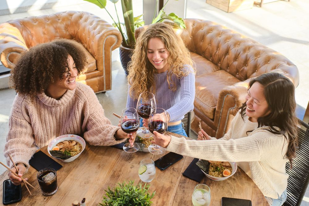 Cheerful diverse women having dinner