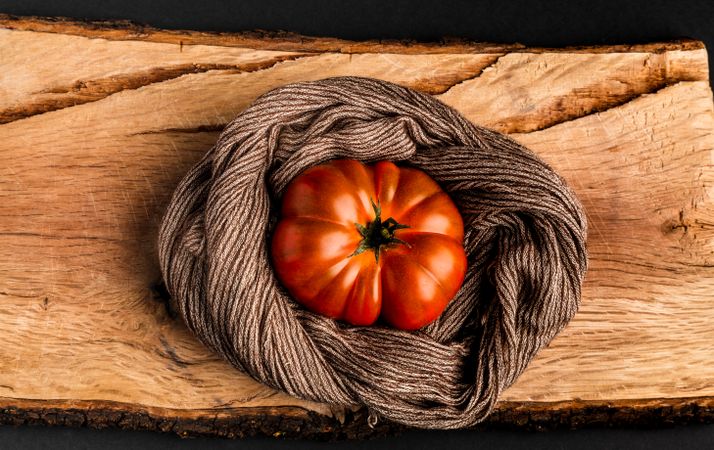 Tomato and napkin on wooden board