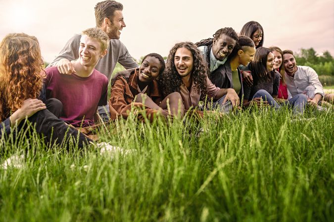Multi-ethnic group of friends sitting together in the grass