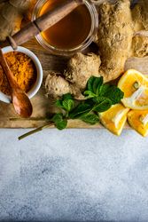 Top view of raw ginger, turmeric & honey on board