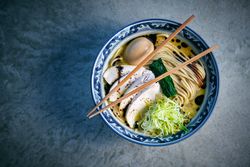 Tasty ramen with noodles and chicken fillet slices in bowl