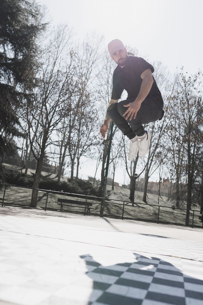 Young man in air dancing break dance in park