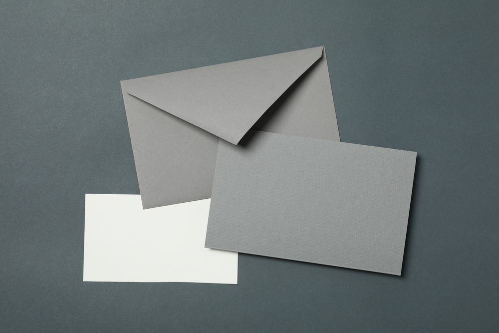 Blank envelope and cards on light dark background, space for text