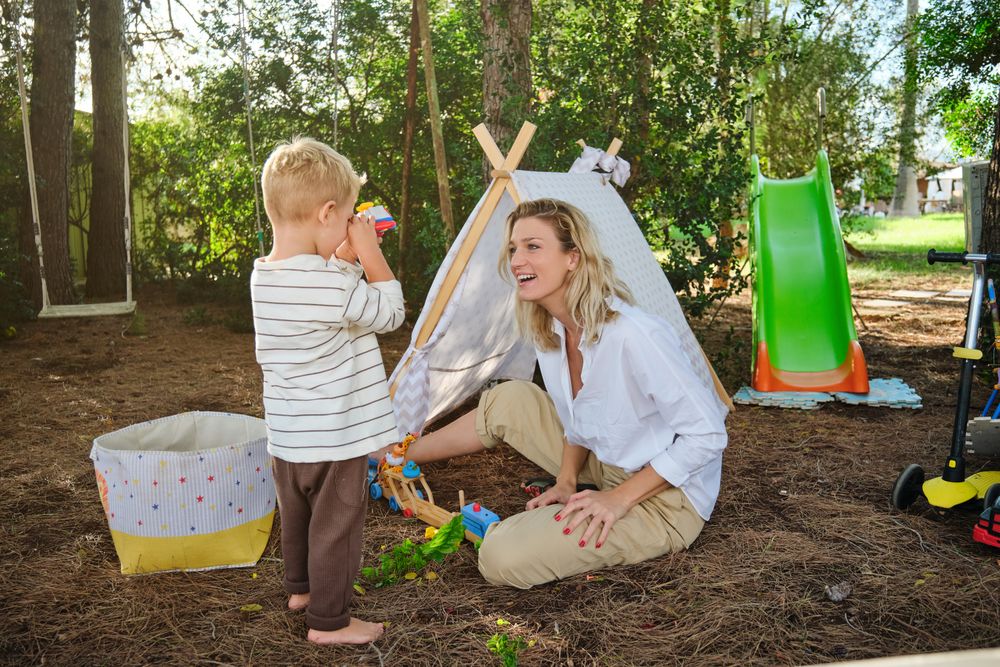 Happy mother and son playing with toys in park