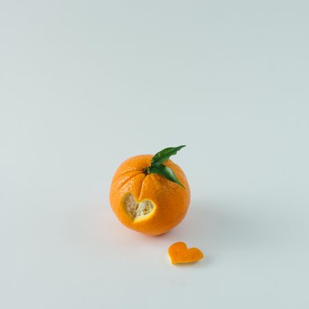 Orange with heart shaped cutout on  table