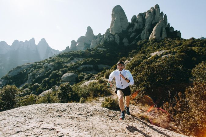 Male running on rugged terrain outside for ultra trail competition