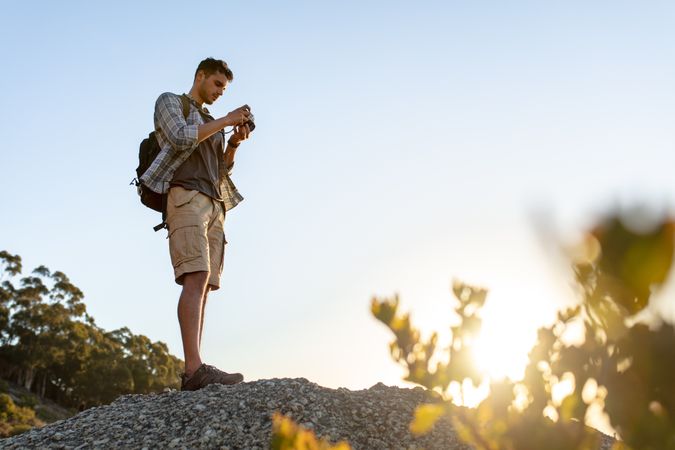 Male hiker with camera on hill top