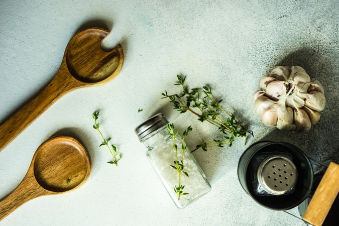 Salt and pepper shakers, thyme and garlic on marble counter with copy space