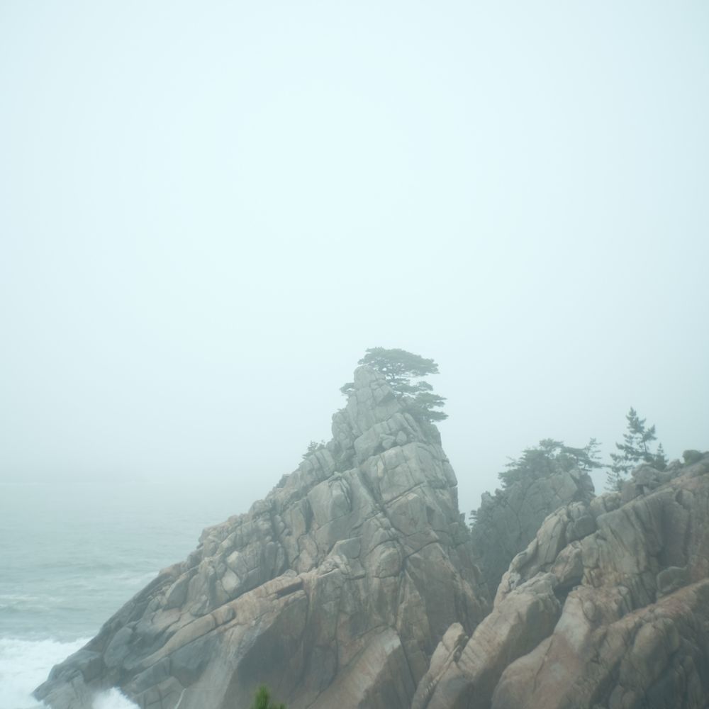 Brown rocky mountain near raging ocean