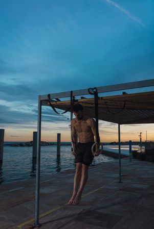 Athletic man balancing on gymnastic rings