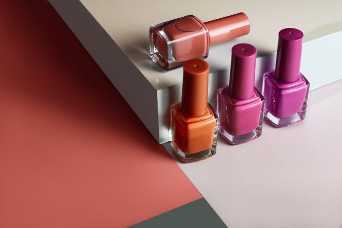 Multi-colored nail polish on pastel colors geometric pattern background