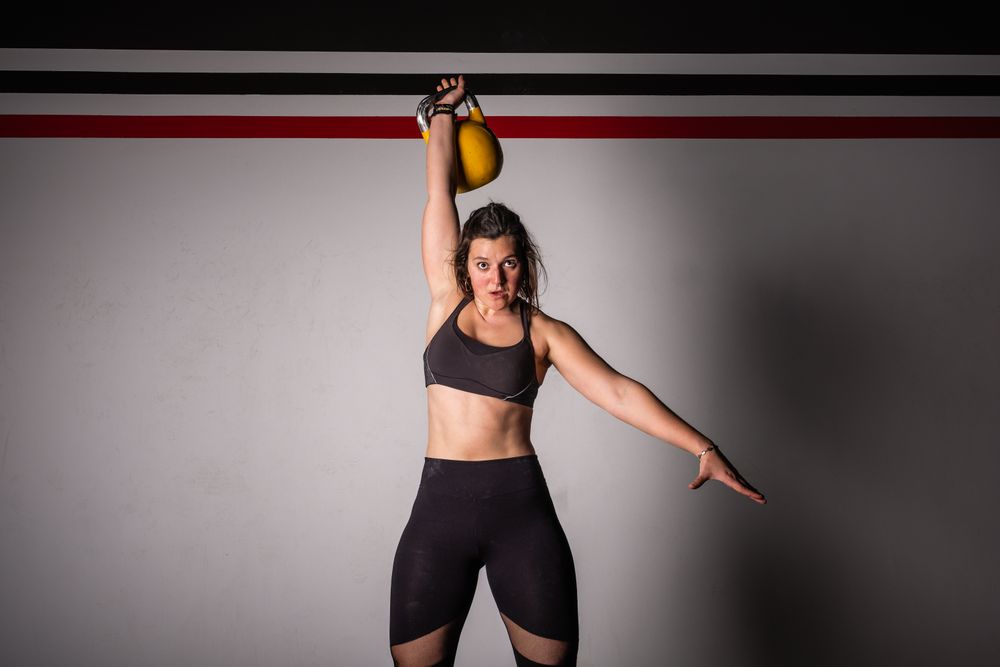 woman lifting kettlebell in gym