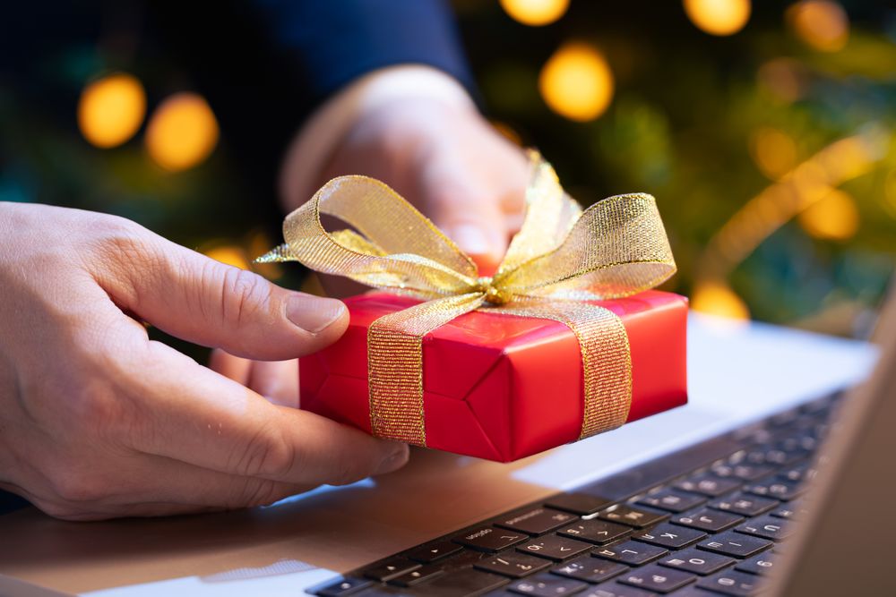 Businessman Holding Gift at Laptop