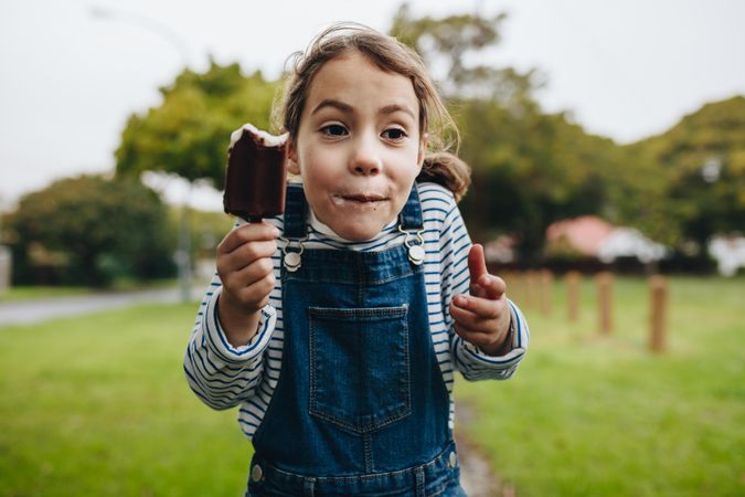 Portrait of adorable little girl enjoying eating ice cream
