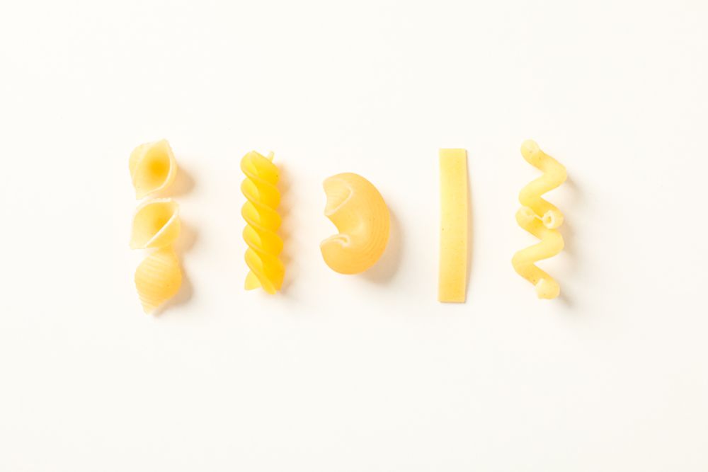 Flat lay composition with pasta on bright background, space for text