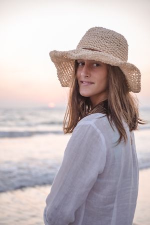 Charming woman in light white dress on wavy beach