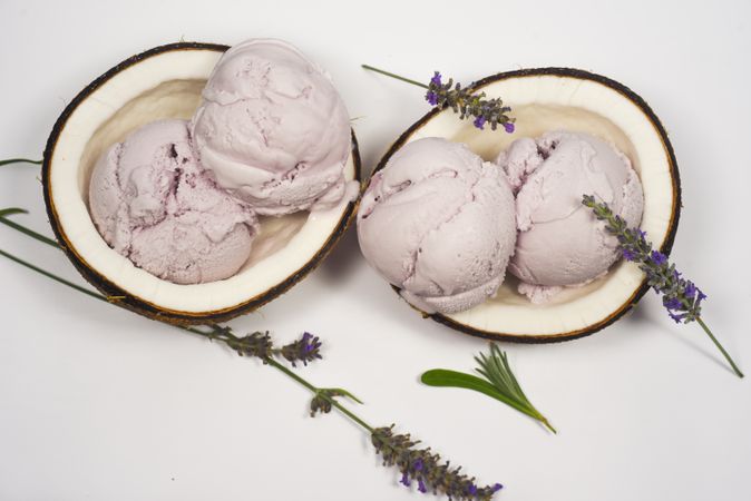 Top view of coconut shells with delicious purple ice cream and garnished with lavender flowers