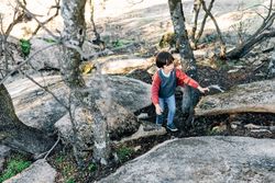 Little boy walking on rocky hill