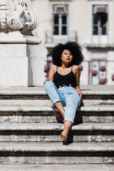 Black female sitting on stairs outdoors